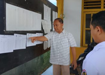 Ketua KPU Provinsi Gorontalo, Sophian Rahmola saat memeriksa papan pengumuman DPT di Desa Teratai, Marisa, Pohuwato, Rabu (25/9/2024).