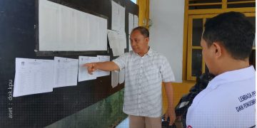 Ketua KPU Provinsi Gorontalo, Sophian Rahmola saat memeriksa papan pengumuman DPT di Desa Teratai, Marisa, Pohuwato, Rabu (25/9/2024).