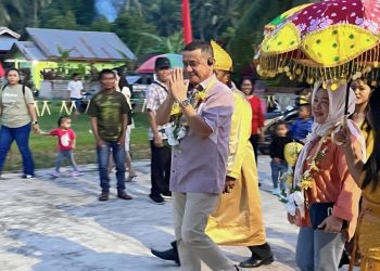 Anggota DPD RI, Syarif Mbuinga didampingi istri saat disambut adat suku Sangihe di Desa Karangetan, Kecamatan Dengilo, Pohuwato, Sabtu (8/2/2025).