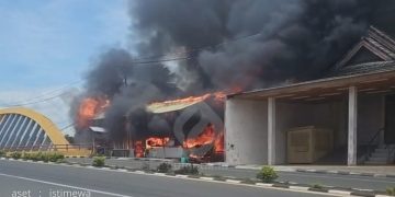 Si Jago merah saat melahap bangunan semi permanen kios di Jembatan Nagit Marisa, Kabupaten Pohuwato, Minggu (16/2/2025).